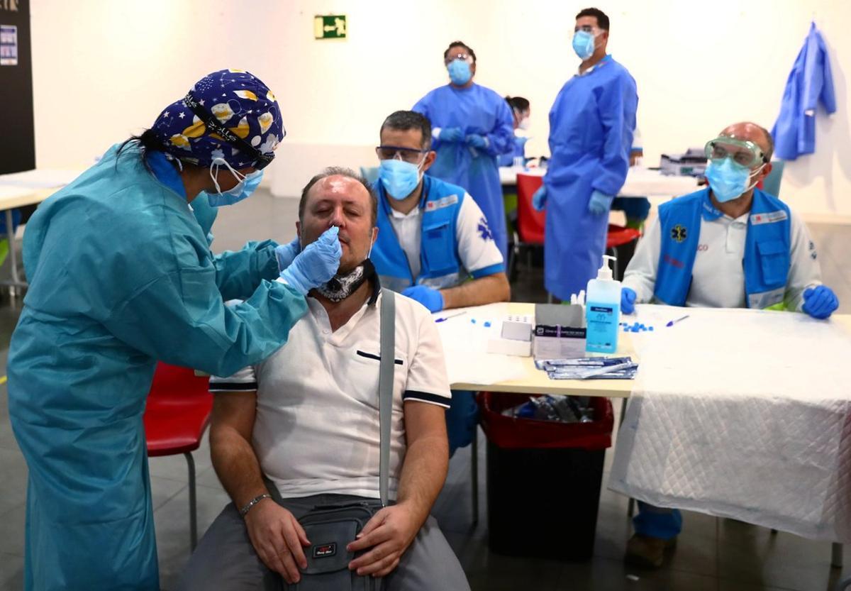 A man has a swab sample taken for a coronavirus disease (COVID-19) antigen test at a cultural centre in the working class neighbourhood of Vallecas in Madrid, Spain October 1, 2020. REUTERS/Sergio Perez