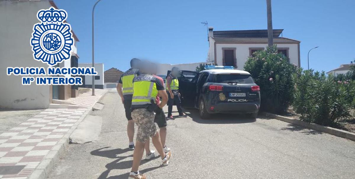 La Policía conduce a otro de los detenidos,