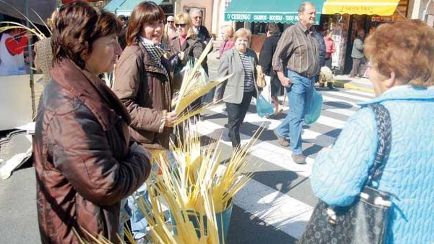 Clientas y vendedoras con las tradicionales palmas en el mercadillo de ayer en Vilagarcía.