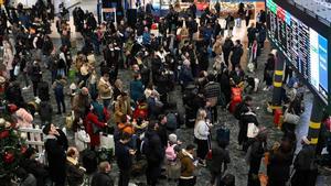 Ciudadanos esperando en la estación londinense de Euston a que salga su tren, en plena huelga en el día de Nochebuena.