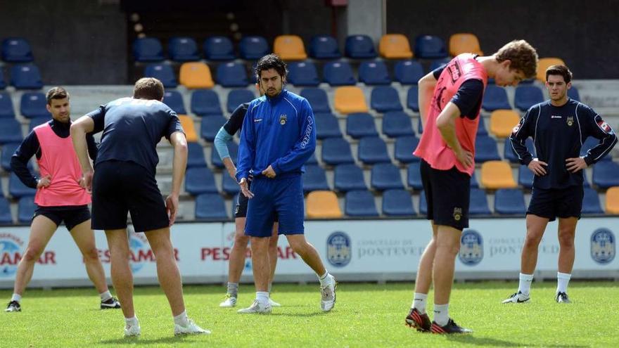 Manu Fernández supervisa uno de los últimos entrenamientos del Pontevedra mientas los jugadores realizar ejercicios de calentamiento. // Rafa Vázquez