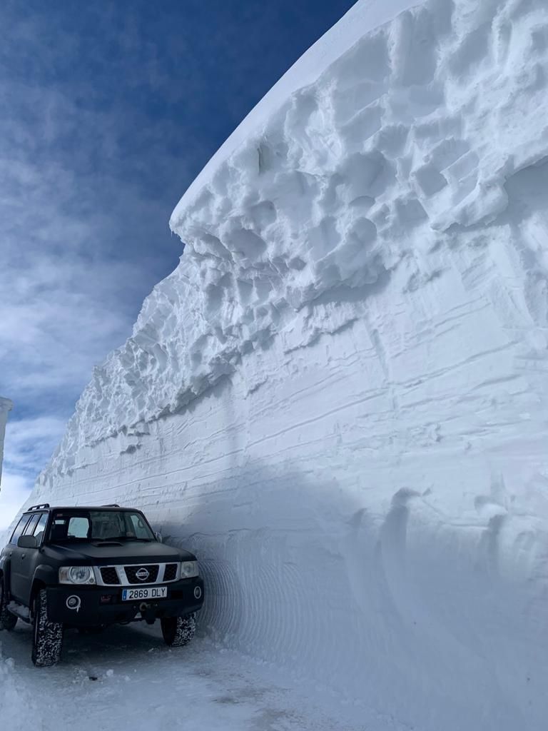 Un coche pasa entre un impresionante muro de nieve, ayer, en la subida al Gamoniteiro.