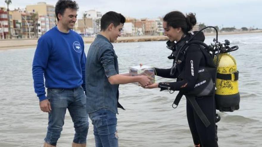 Un dels estudiants entrega l&#039;aquari amb els taurons a una bus.