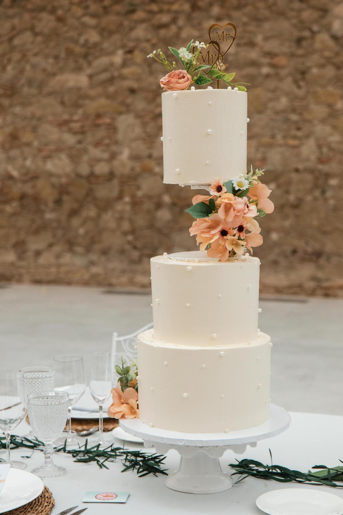 Una tarta nupcial, adornada con perlas.