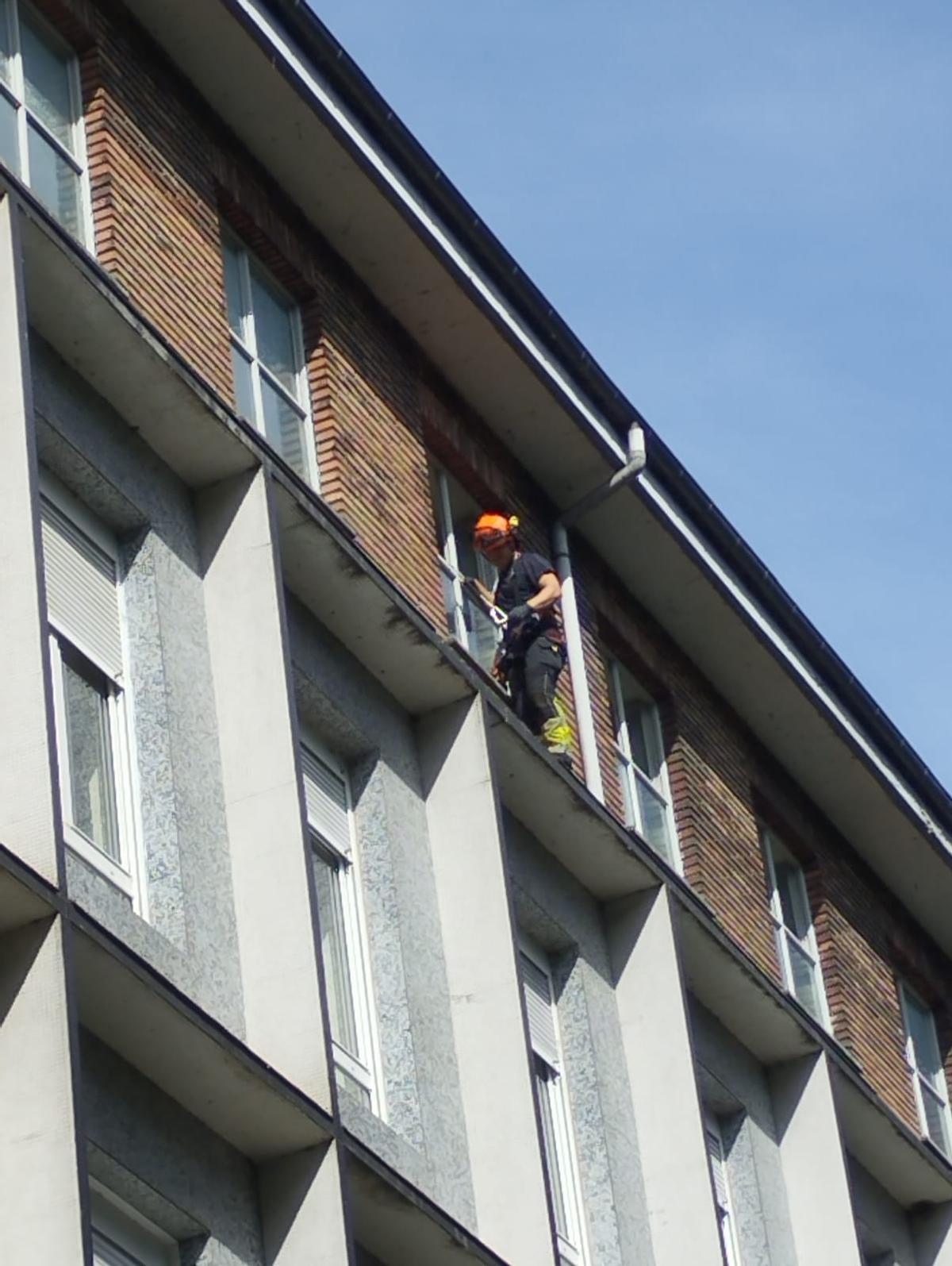 Un bombero, en la cornisa del colegio.
