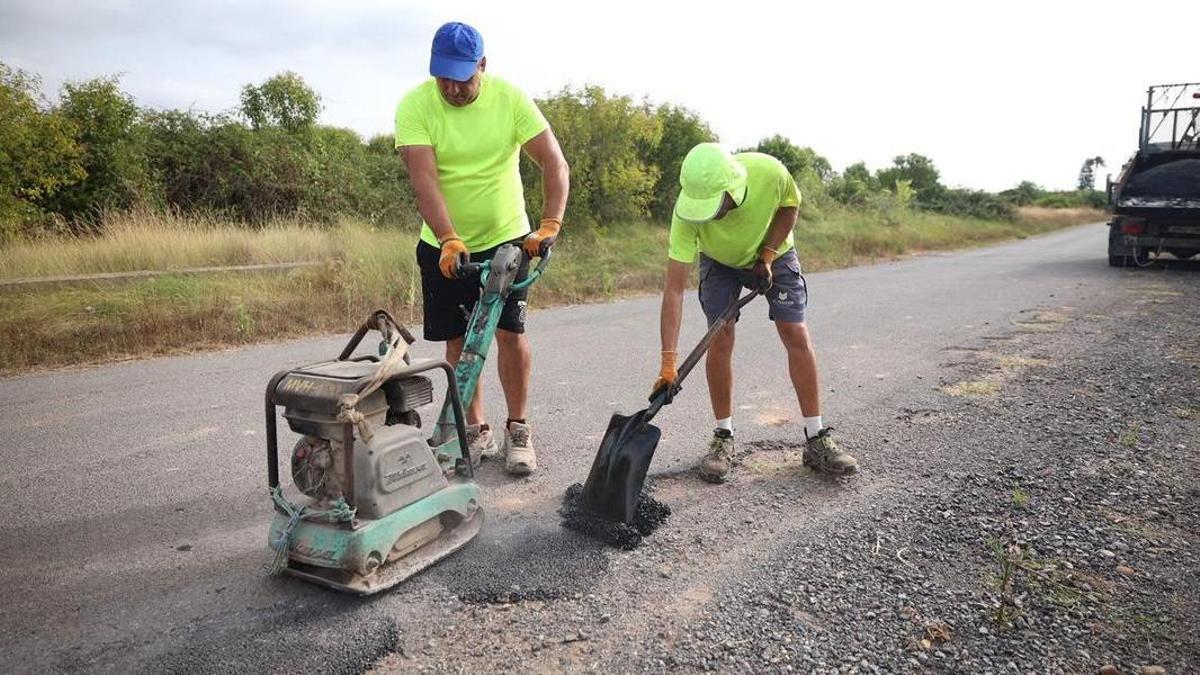 Dos operarios realizan labores de reasfaltado en uno de los viales del municipio.