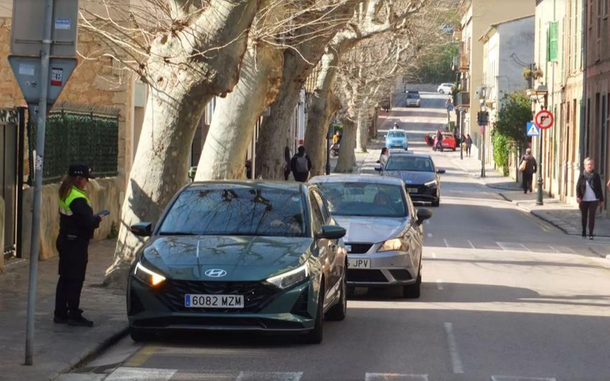 Eine Beamtin der Ortspolizei überprüft am Samstag (28.2.) Fahrzeuge im Zentrum von Sóller