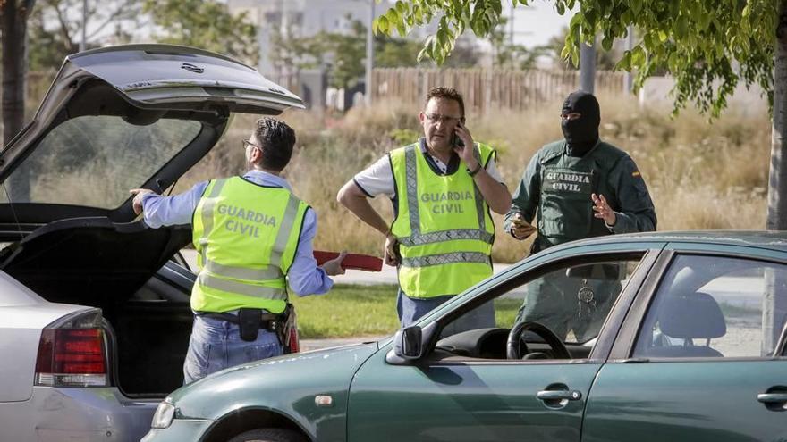 Los guardias civiles, el pasado miércoles, examinan el coche de uno de los sospechosos en la Avenida de México.