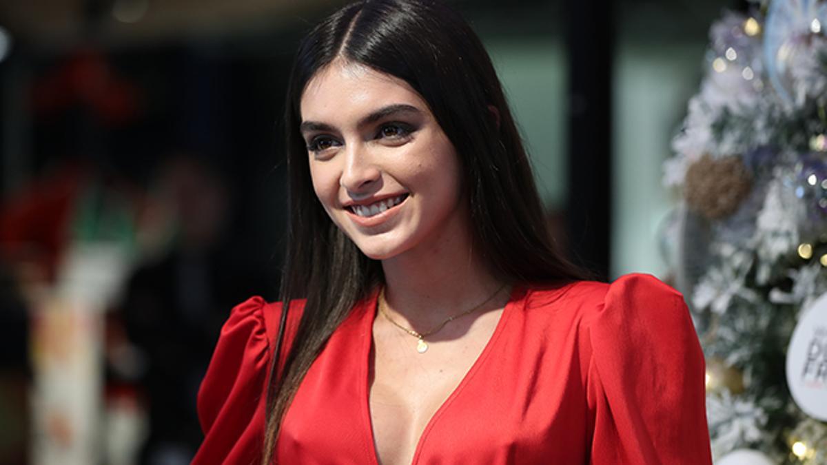 Lucia Rivera con vestido rojo iluminando árbol de Navidad