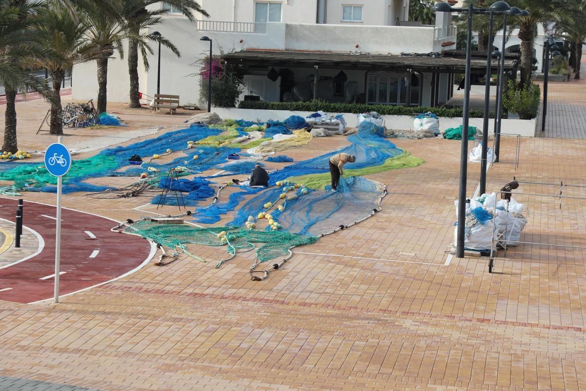 Pescadores remendando redes en el puerto de la Savina
