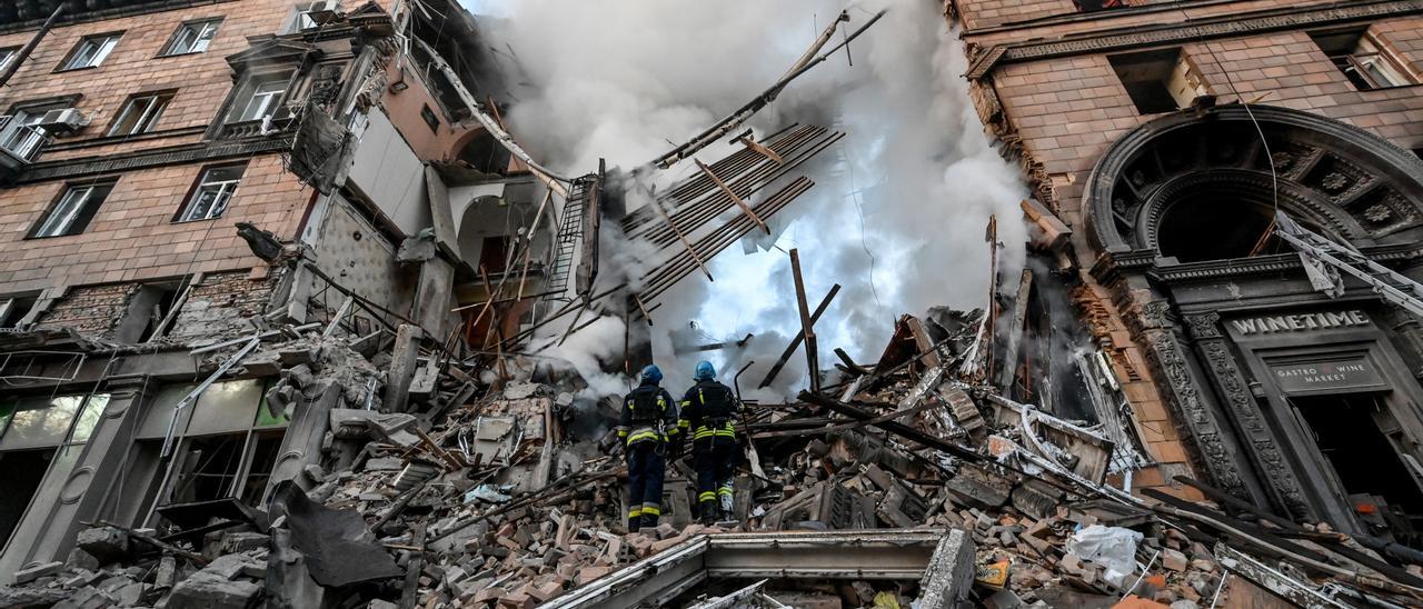 Dos bomberos realizan labores de rescate en Ucrania.