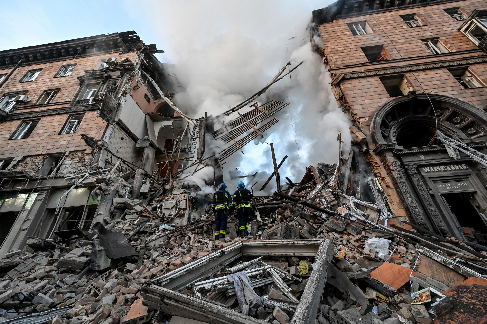 Dos bomberos realizan labores de rescate en Ucrania.