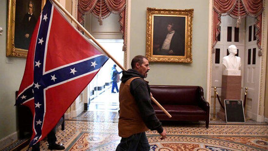 Un partidari del president Donald Trump porta la bandera confederada en l&#039;assalt al Capitoli.