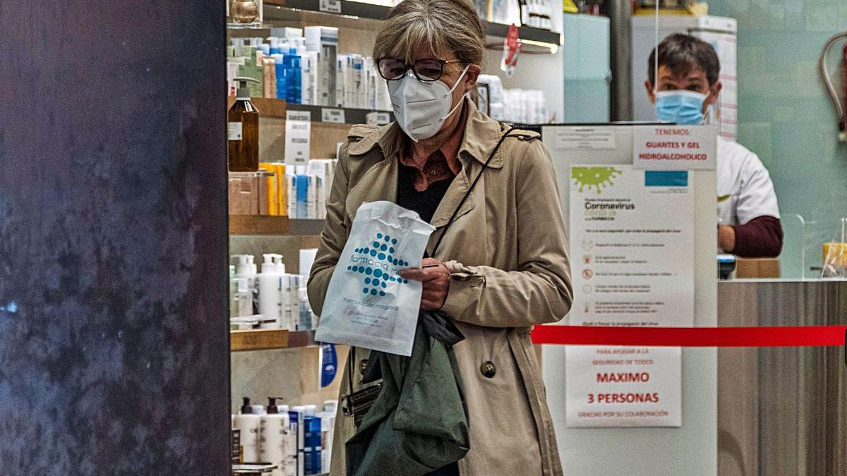 Una mujer compra en una farmacia de la isla durante la pandemia.