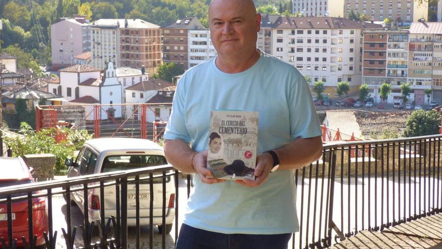 Tito Casado, con un ejemplar de «El cerezo del cementerio», en Cangas del Narcea. | D. Á.