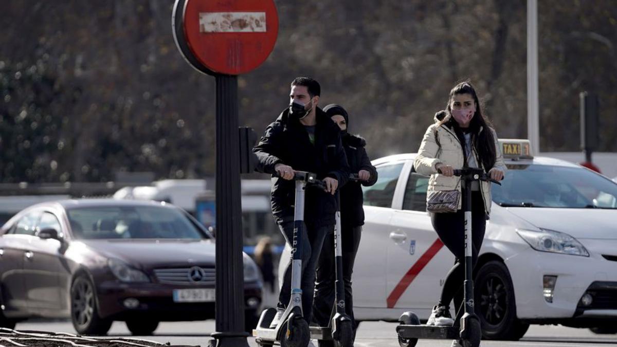Tres joves en patinet elèctric per Barcelona