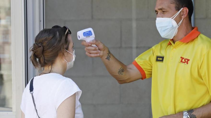 Un sanitari pren la temperatura a una ciutadana durant el cribratge massiu que es va realitzar a Girona