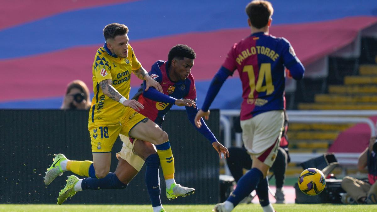 FC Barcelona's Alejandro Balde (C) falls down in front of UD Las Palmas' Viti Rozada (L) during their LaLiga EA Sports match at the olympic stadium Lluis Companys in Barcelona, north-eastern Spain, 30 November 2024. EFE/ Enric Fontcuberta