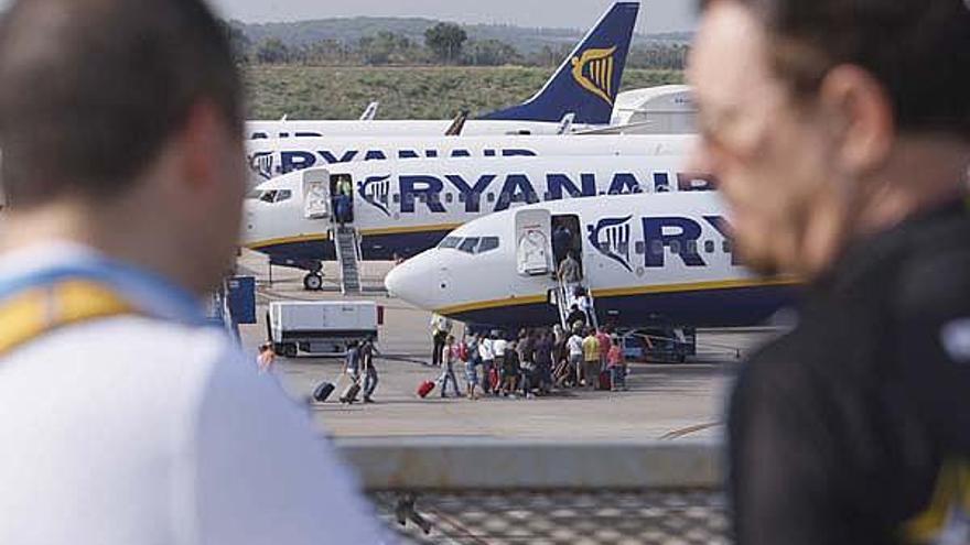 Passatgers embarcant ahir en un avió de Ryanair davant la mirada d&#039;altres usuaris de l&#039;aeroport.