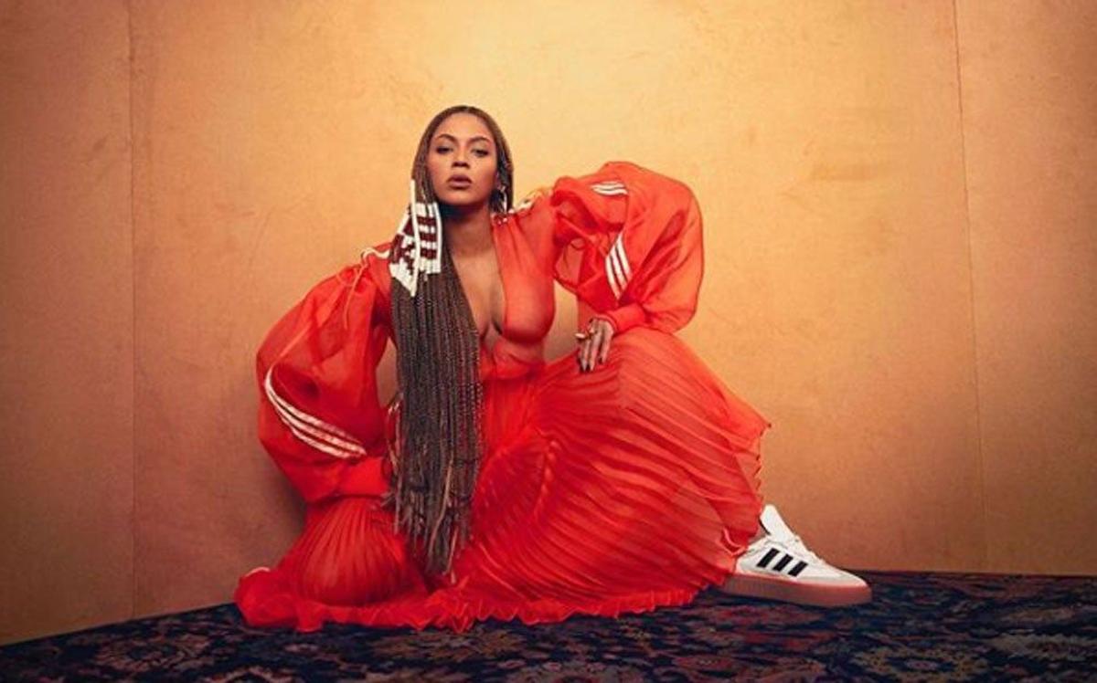 Beyoncé con vestido rojo y zapatillas Adidas