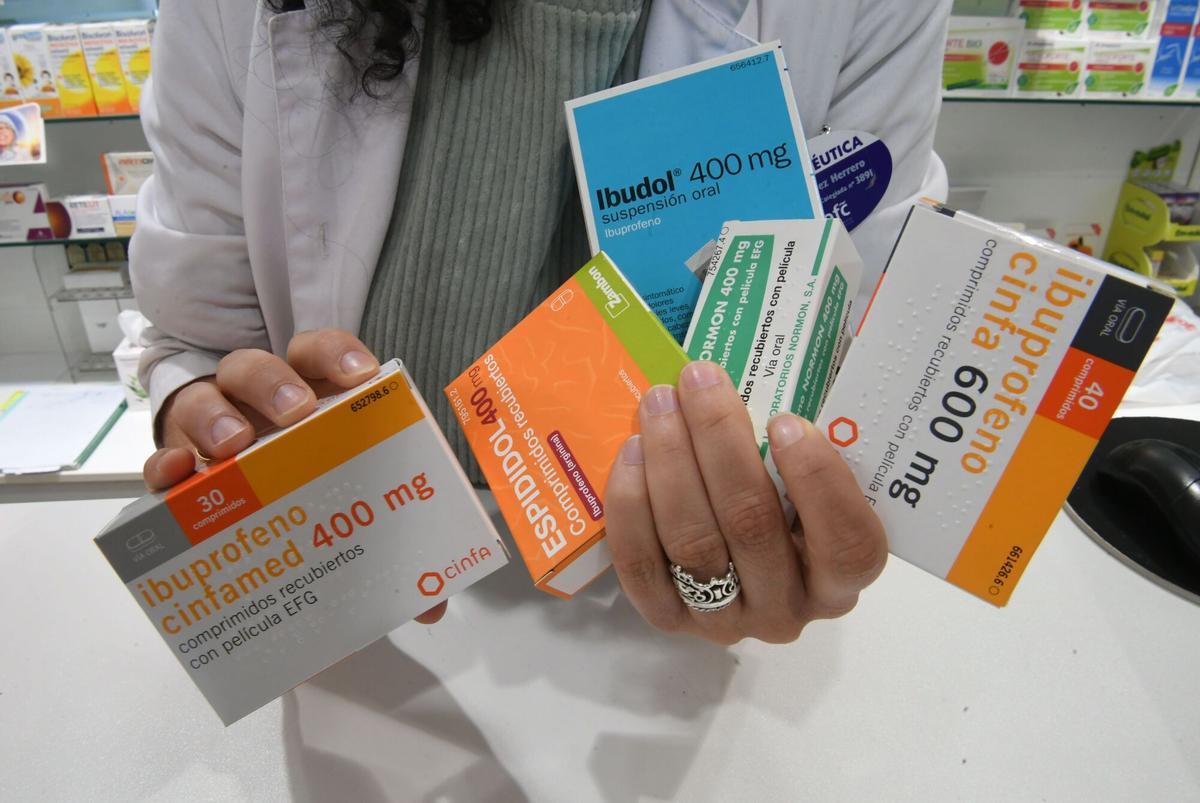 Varias cajas de medicamentos genéricos en una farmacia.