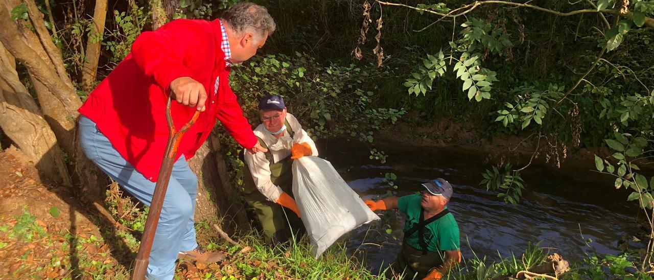 El edil sierense Alejandro Villa con los responsables del colectivo de pescadores que limpia el río