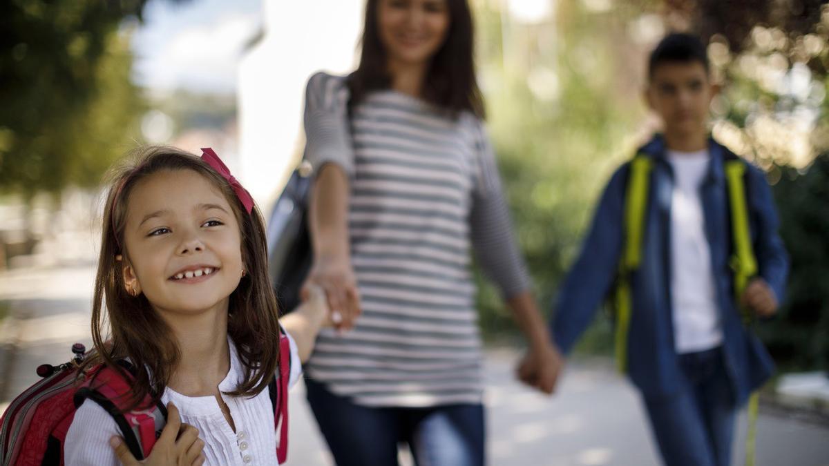 Madre e hijos de camino al colegio.