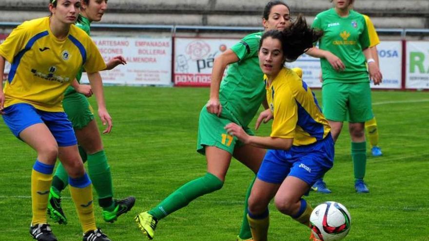 Nuria trata de hacerse con un balón ante la mirada de su compañera Ari Martínez. // Iñaki Abella