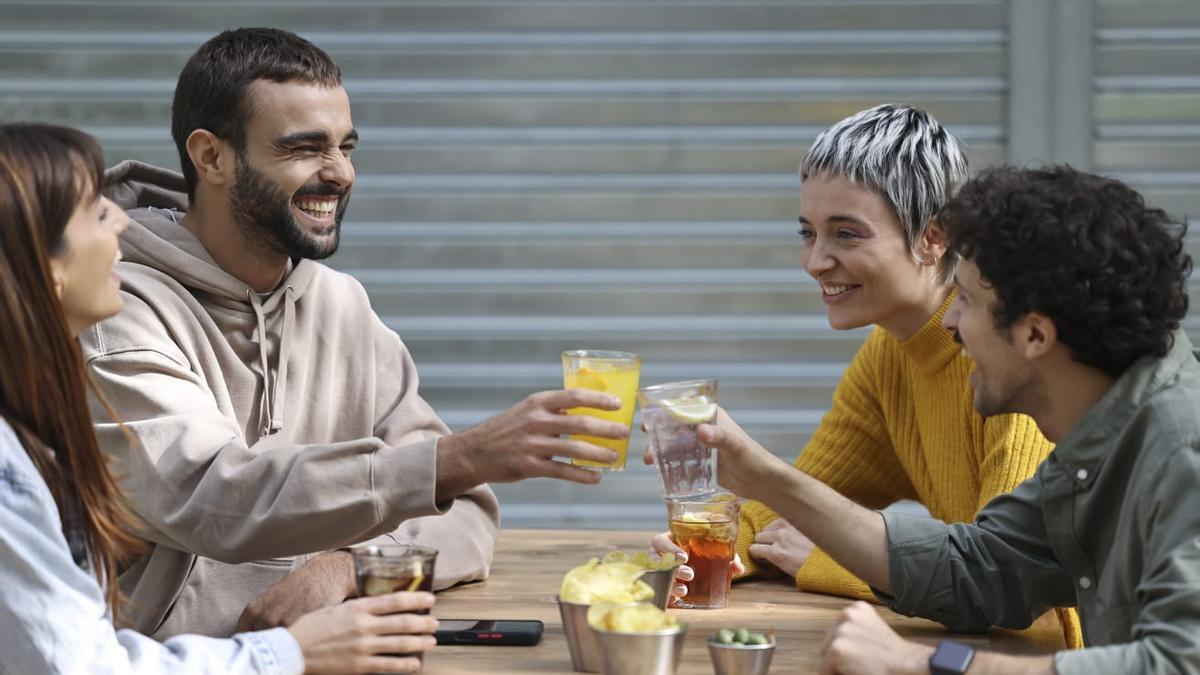 Un grupo de jóvenes tomando algo en una terraza; la principal actividad de ocio de los españoles