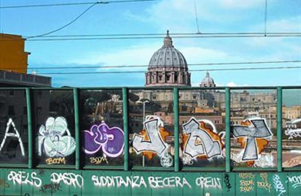 Una pintada en una tanca de Roma amb la cúpula de la basílica de Sant Pere, al fons. Una pintada en una tanca de Roma amb la cúpula de la basílica de Sant Pere, al fons.