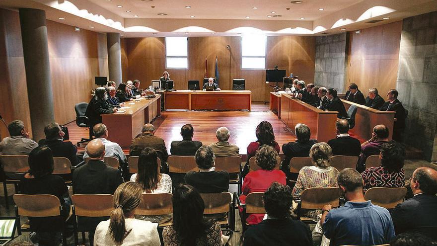 La sala de vistas, con el juez en el centro y los abogados a los lados, y frente a ellos los acusados, sentados en primera fila, de espaldas.