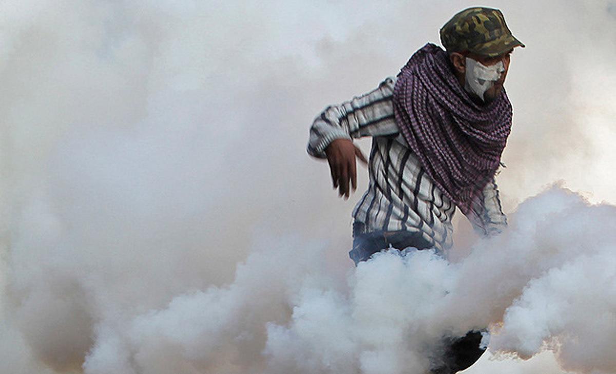 Un manifestant intenta fugir dels gasos lacrimògens, durant els enfrontaments a la plaça Tahrir, al Caire.