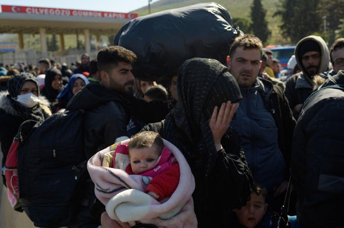 Los residentes sirios de la ciudad de Hatay esperan para cruzar la frontera entre Turquía y Siria después de que se vieron afectados por el terremoto de magnitud 7,8 que asoló la región hace casi dos semanas, en la puerta fronteriza de Cilvegozu