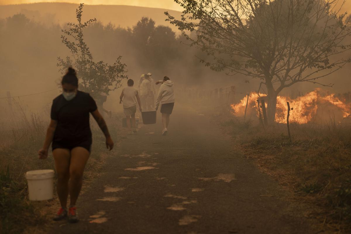 Vecinos trabajan en labores de extinción del incendio forestal de Carballeda de Avia (Ourense) este domingo. La ola de incendios que afecta al noroeste de España no da tregua este domingo. Tras una semana de incendios que han causado tres muertos, miles de hectáreas quemadas y miles de desalojados por las llamas, el país se encuentra devastao. En la región de Galicia ardieron ya 50.000 hectáreas y en la de Castilla y León 3.500 personas permanecían fuera de sus hogares. EFE/ Brais Lorenzo