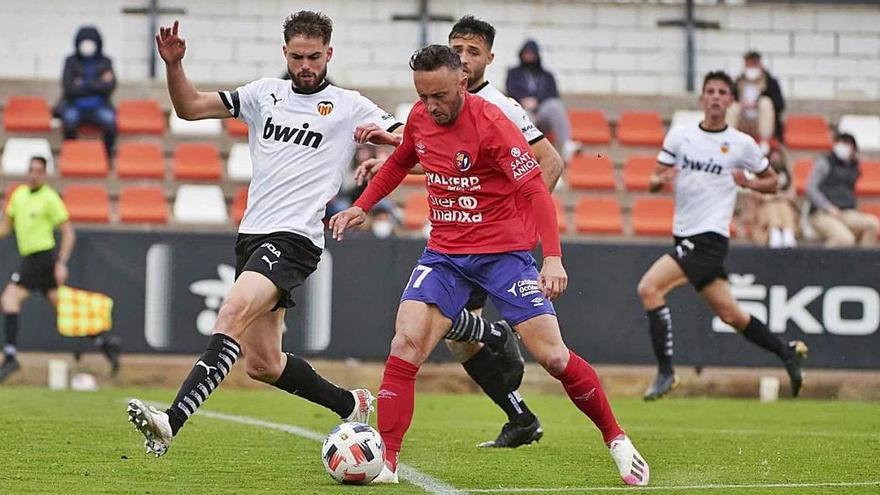 Jordi Xumetra intenta escapar-se de dos jugadors del València Mestalla dissabte passat