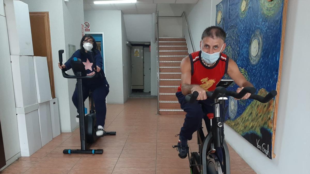 Dos usuarios del centro Juan María de Nigrán pedalean en las bicicletas / bicis estáticas. Centro Juan María.