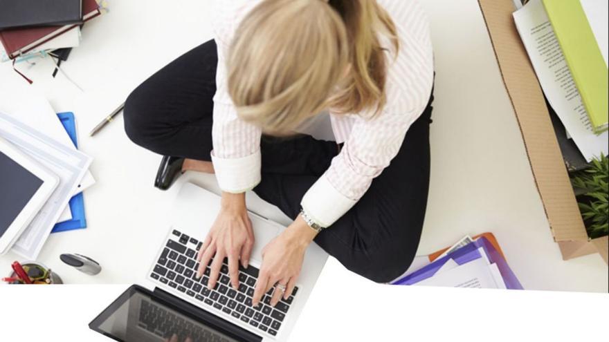 Una mujer trabajando frente al ordenador.