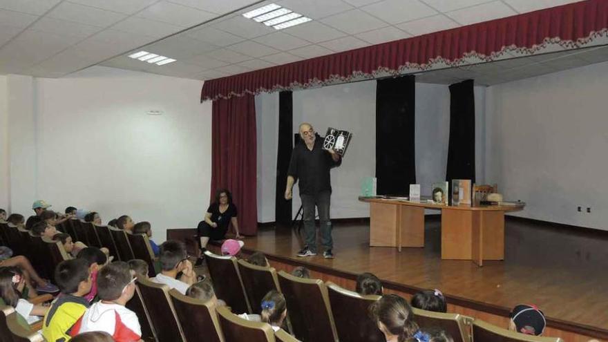 Fernando Martos muestra un libro con ilustraciones al público infantil.