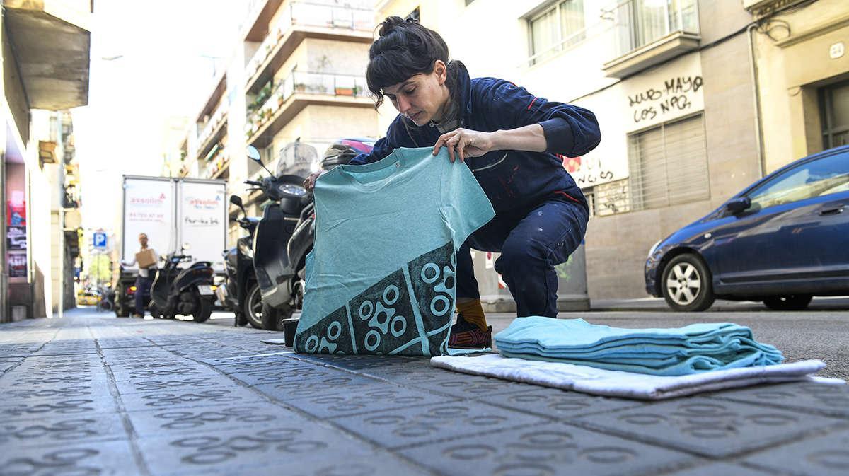 Emma France Raff estampa una camiseta sobre la acera de la calle Sant Lluís, en Gràcia.  