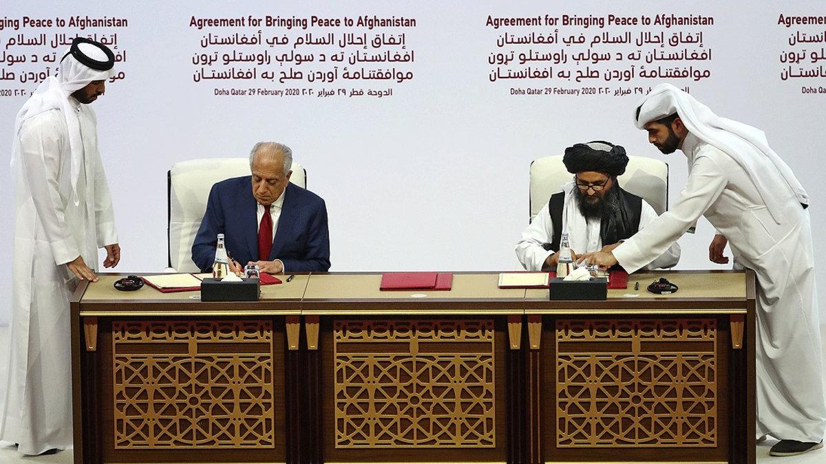 El enviado especial de EEUU, Zalmay Khalilzad, y el líder político talibán, Mullah Abdul Ghani Baradar, firman el acuerdo de paz, este sábado en Doha