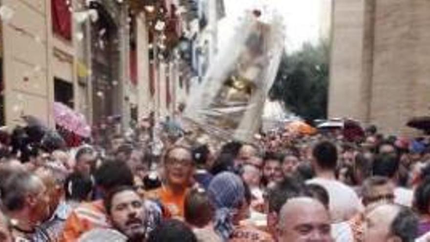 Los «eixidors», de naranja, haciendo pasillo a la Virgen por la calle Micalet hasta la Catedral.