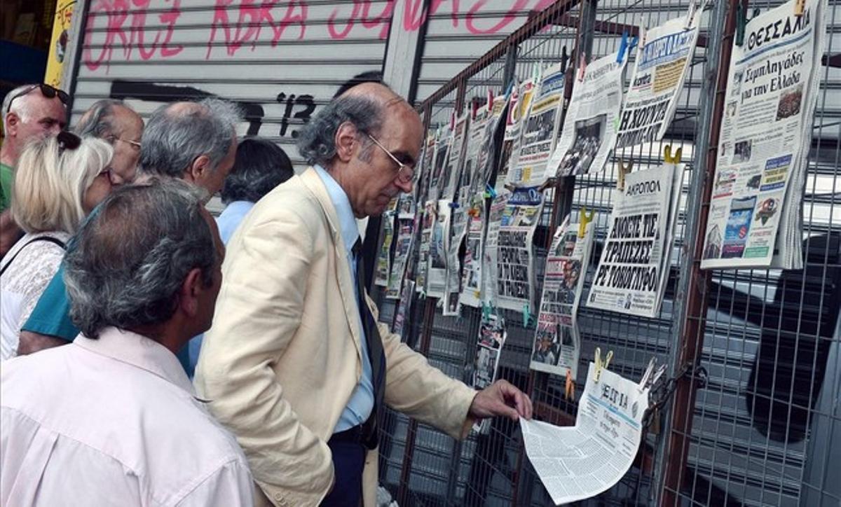 Ciudadanos griegos leen los titulares de la prensa en el centro de Atenas.
