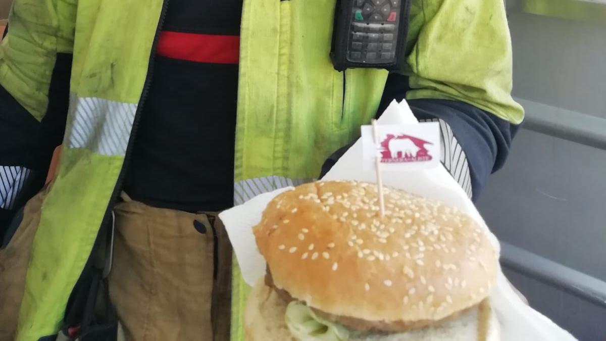 Un brigadista con una de las hamburguesas donadas.