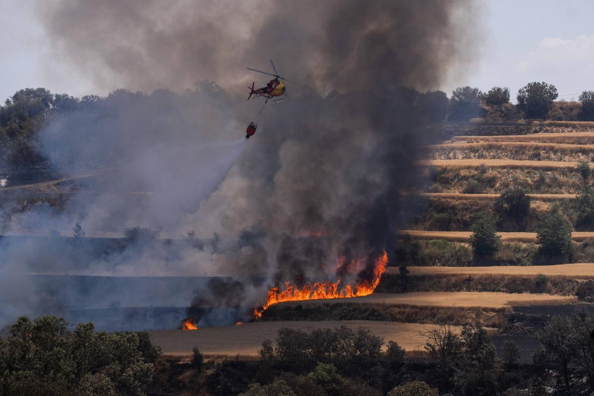 Helicópteros de bomberos asisten en la extinción de los focos que reaparecen en Guardiola, Lleida, este 2 de julio de 2025. Un día después del incendio que, según las investigaciones, se originó por una segadora en Torrefeta, las labores de control continúan.