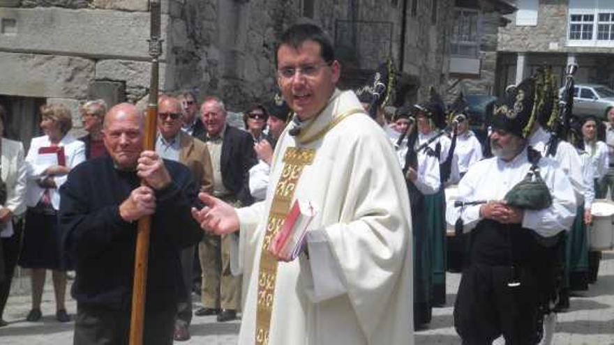 El sacerdote Jorge Flórez seguido por la banda de música «As Portelas» durante los actos de la reapertura de la iglesia de San Mamed.