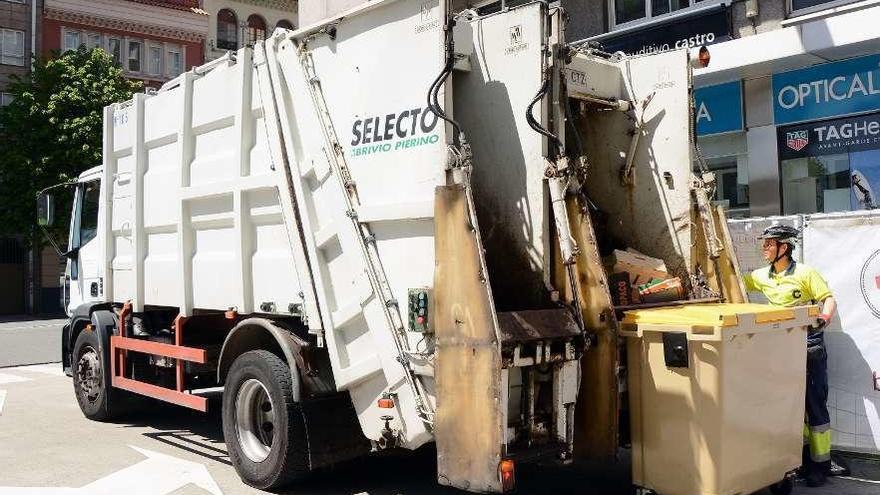 Un operario de la recogida de basura vacía un contenedor en un camión.