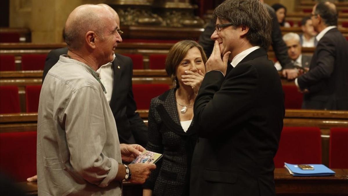 El 'president' Carles Puigdemont conversa con el diputado Lluís Llach y la presidenta del Parlament, Carme Forcadell, poco antes de comenzar el debate de política general.