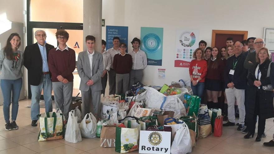 Alumnos y profesores del Colegio Agora Portals junto a los productos y alimentos recaudados.