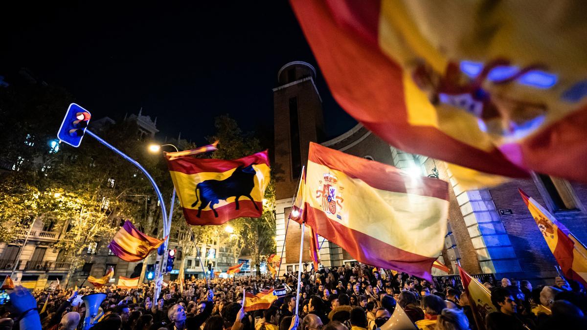 Cientos de personas con banderas durante una manifestación contra la amnistía frente a la sede del PSOE en Madrid, en la calle de Ferraz.