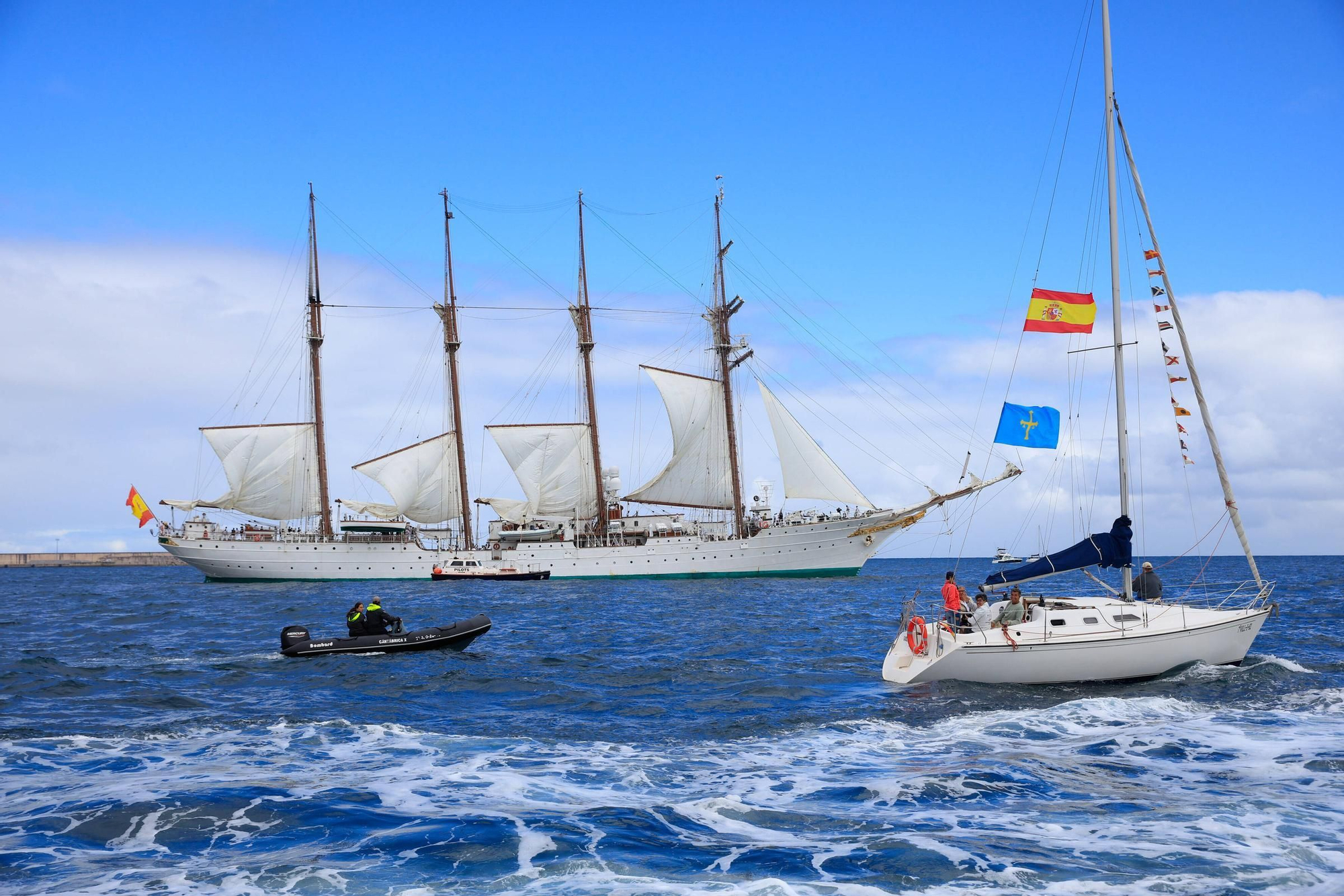 En imágenes: así se despidieron más de 40 embarcaciones del "Elcano" y la "Blas de Lezo" surcando la costa de Gijón